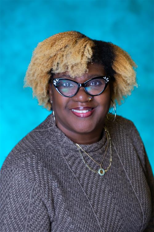 black woman with black glasses and blonde hair